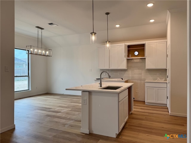 1249 Bending Branch Way, Temple, TX 76502 - kitchen with a sink, tasteful backsplash, a chandelier, white cabinets, and light wood finished floors