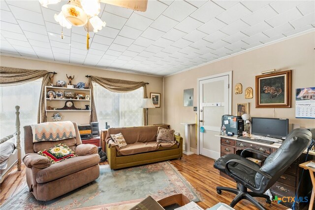 living room featuring hardwood / wood-style flooring, ceiling fan, and ornamental molding