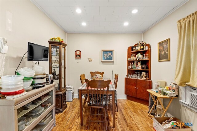 dining area with light wood-type flooring and crown molding