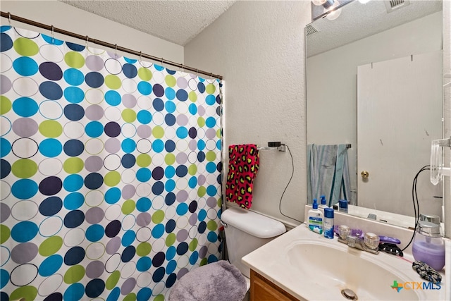 bathroom with vanity, a textured ceiling, and toilet