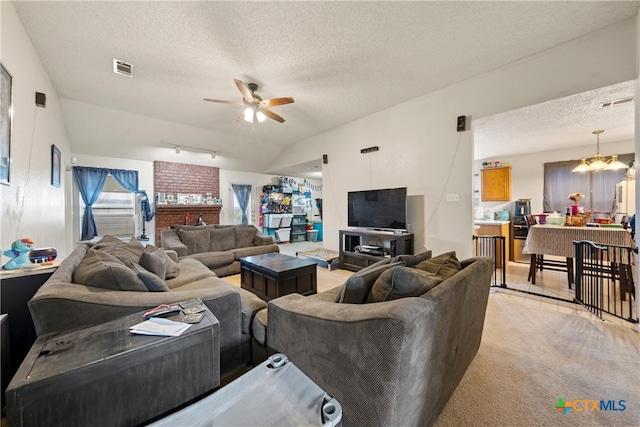 carpeted living room with ceiling fan with notable chandelier, a textured ceiling, and lofted ceiling