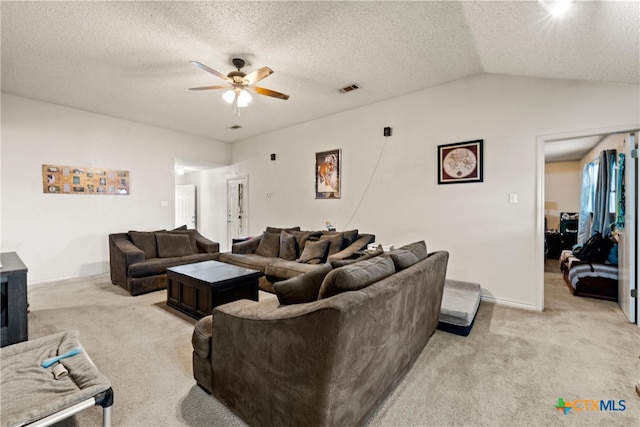 carpeted living room with ceiling fan, a textured ceiling, and vaulted ceiling