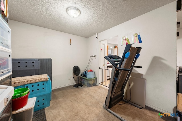 exercise room with light carpet and a textured ceiling