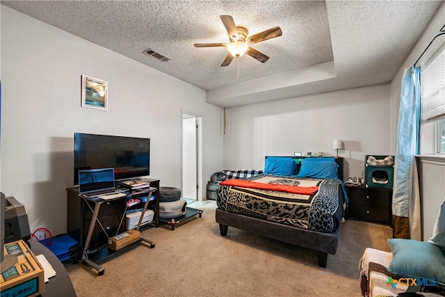 bedroom featuring ceiling fan, carpet floors, and a textured ceiling