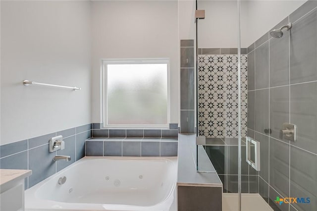 bathroom featuring a jetted tub and a shower stall