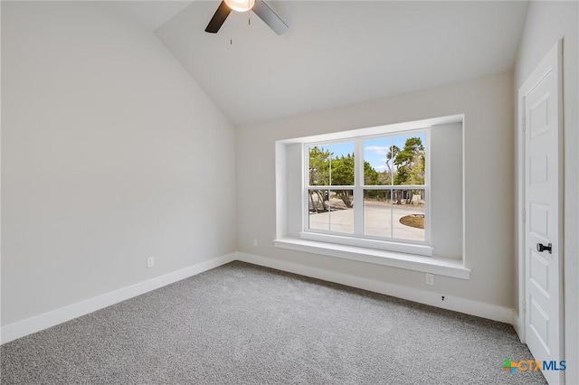 carpeted spare room featuring a ceiling fan, lofted ceiling, and baseboards