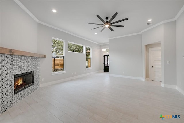 unfurnished living room featuring baseboards, visible vents, crown molding, and a tiled fireplace