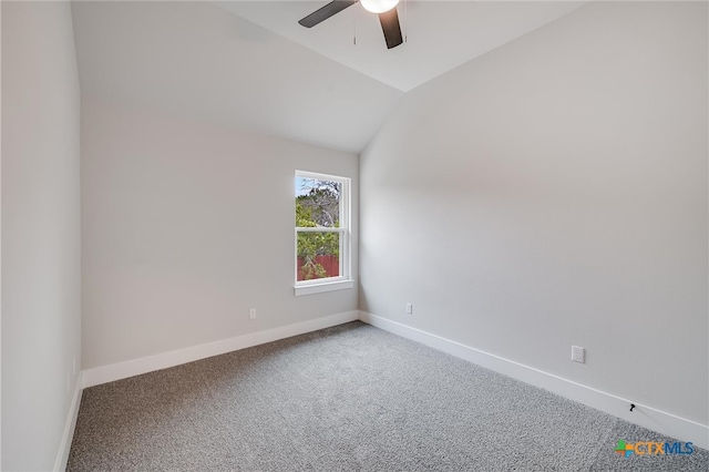 carpeted spare room featuring vaulted ceiling, ceiling fan, and baseboards