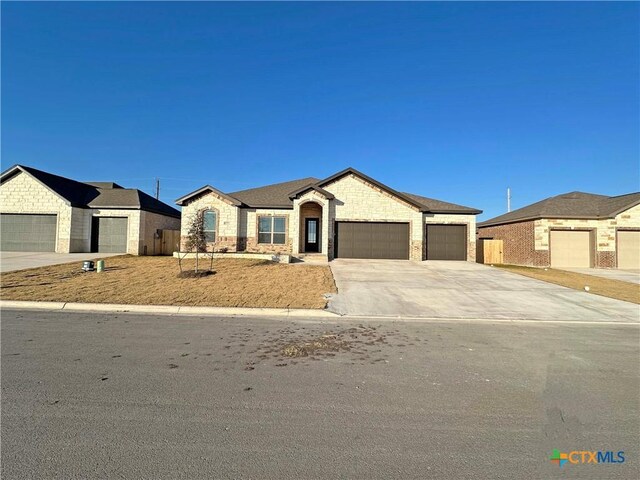 single story home featuring a garage and a front lawn