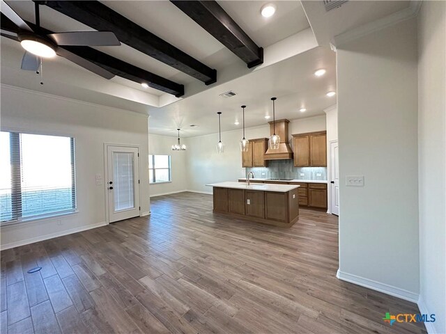 unfurnished living room with dark hardwood / wood-style floors, ceiling fan, ornamental molding, and beam ceiling