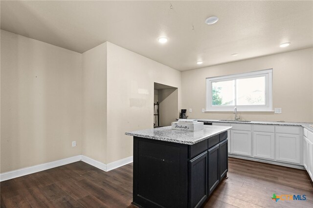 607 S Main St, Lampasas, TX 76550 - kitchen with dark wood-style floors, a center island, dark cabinets, light stone countertops, and recessed lighting