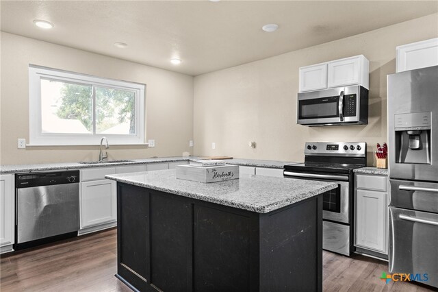 607 S Main St, Lampasas, TX 76550 - kitchen featuring appliances with stainless steel finishes, white cabinetry, a kitchen island, wood finished floors, and recessed lighting
