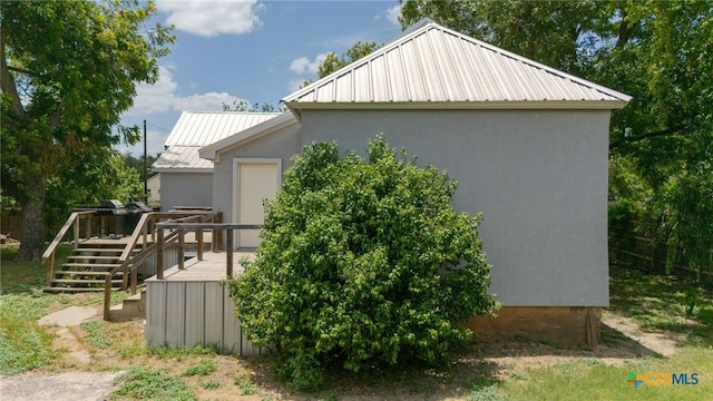 607 S Main St, Lampasas, TX 76550 - view of property exterior featuring a metal roof, a wooden deck, stucco siding, and stairs