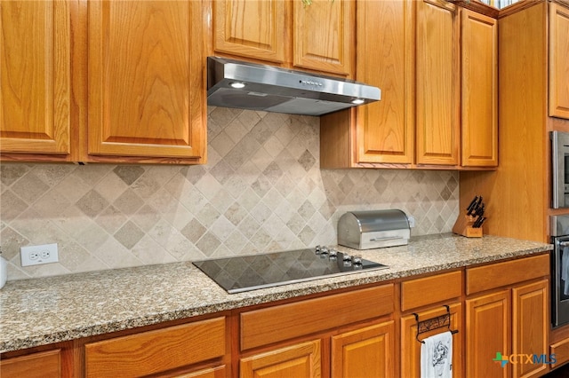 kitchen with brown cabinetry, stainless steel oven, black electric cooktop, and under cabinet range hood