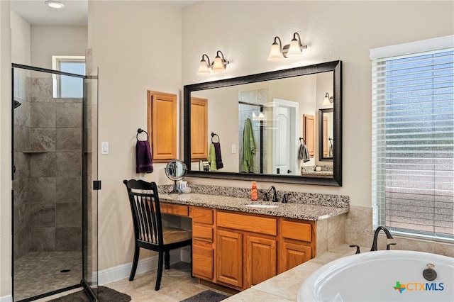 full bathroom featuring a garden tub, a shower stall, vanity, and baseboards