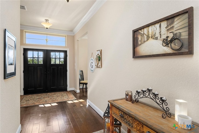 entrance foyer featuring french doors, visible vents, hardwood / wood-style floors, ornamental molding, and baseboards