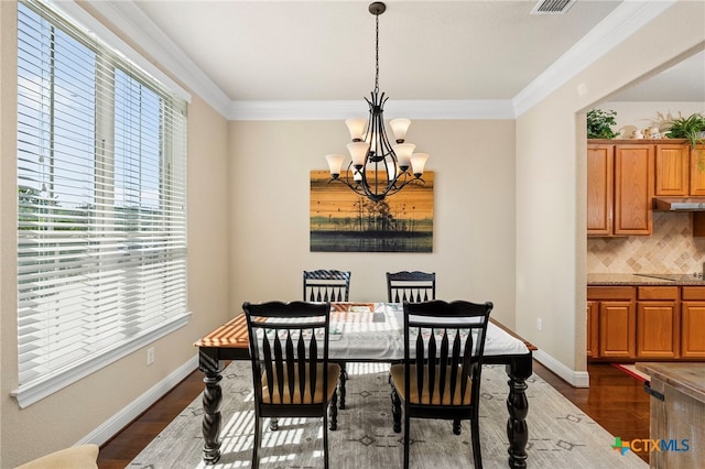 dining area featuring ornamental molding, dark wood-style flooring, a notable chandelier, and baseboards