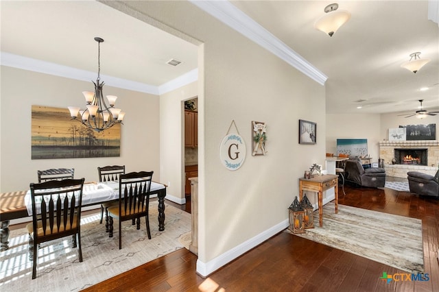 dining area featuring ornamental molding, dark wood-style flooring, a fireplace, and baseboards