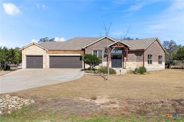 ranch-style home featuring concrete driveway, stone siding, roof with shingles, an attached garage, and brick siding