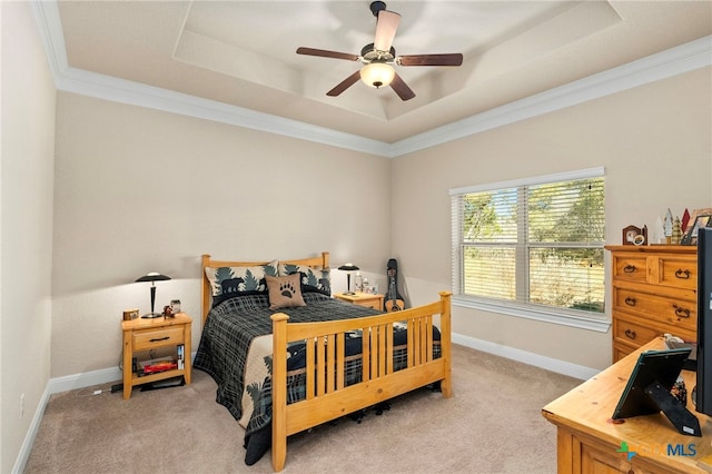 carpeted bedroom with a ceiling fan, baseboards, a raised ceiling, and crown molding