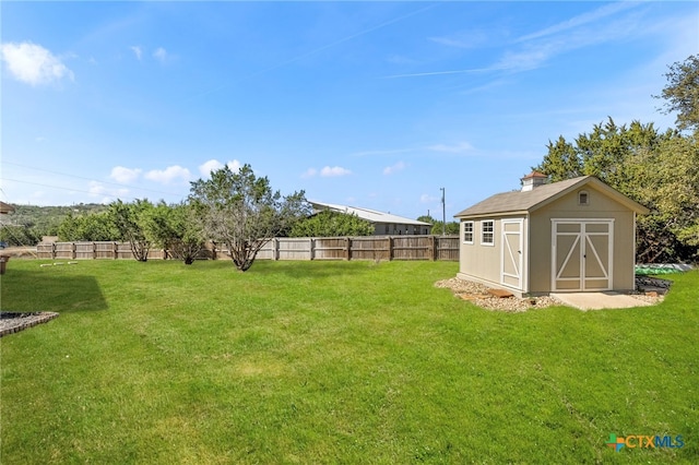 view of yard featuring a shed, fence, and an outdoor structure