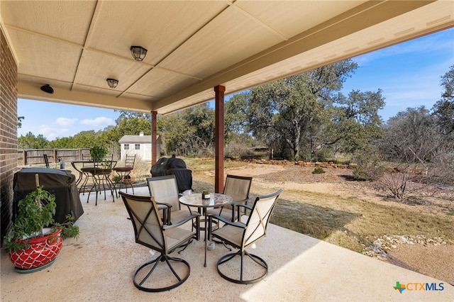 view of patio with outdoor dining space, a grill, an outdoor structure, and a storage unit