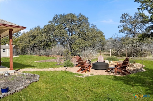 view of yard with an outdoor fire pit and an outbuilding