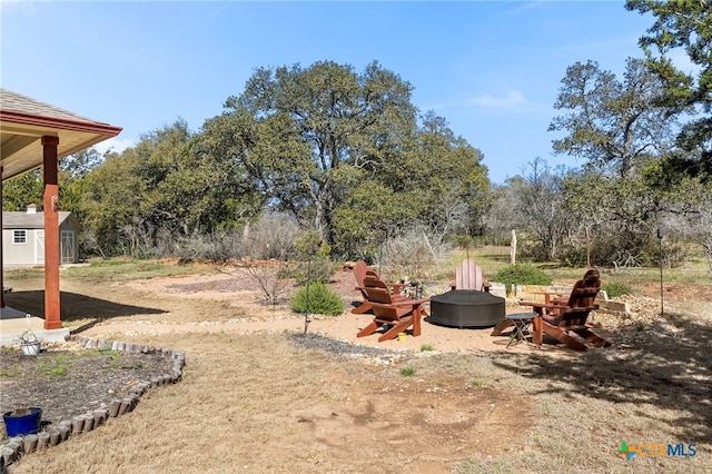 view of yard with an outdoor fire pit and an outdoor structure