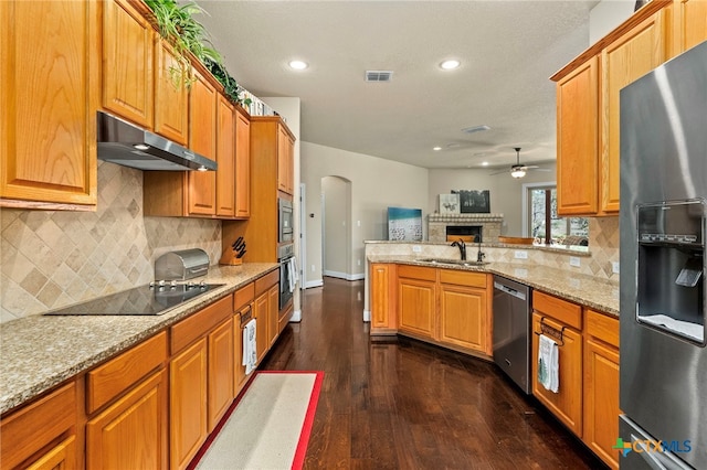 kitchen with visible vents, appliances with stainless steel finishes, a peninsula, under cabinet range hood, and a sink