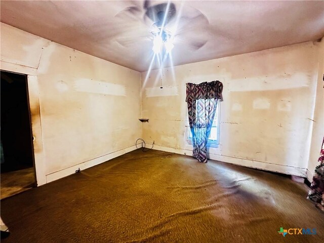 201 Maple St, Yoakum, TX 77995 - spare room featuring dark colored carpet and baseboards