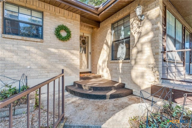 view of exterior entry featuring brick siding