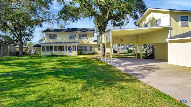 view of front of house featuring a sunroom, a carport, and a front lawn