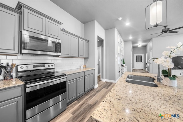 kitchen featuring hardwood / wood-style floors, gray cabinetry, sink, and appliances with stainless steel finishes