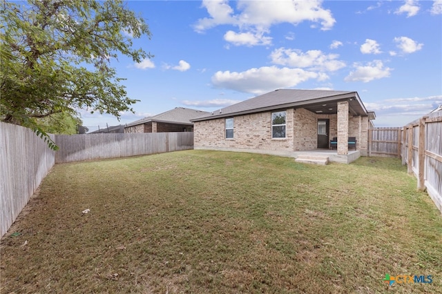 rear view of house with a lawn and a patio area