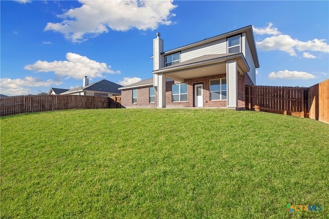 rear view of property featuring a lawn