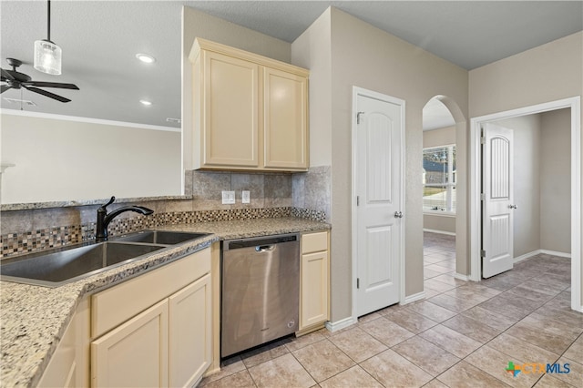 kitchen with ceiling fan, dishwasher, sink, cream cabinets, and decorative backsplash