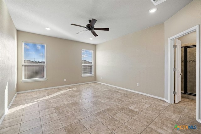 empty room with ceiling fan and light tile patterned floors