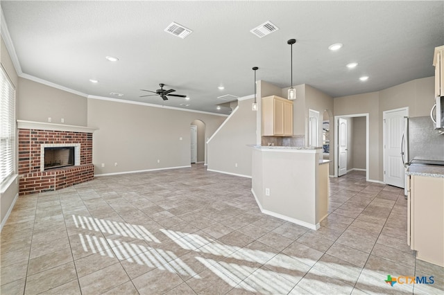 kitchen featuring pendant lighting, light tile patterned floors, a brick fireplace, and ceiling fan