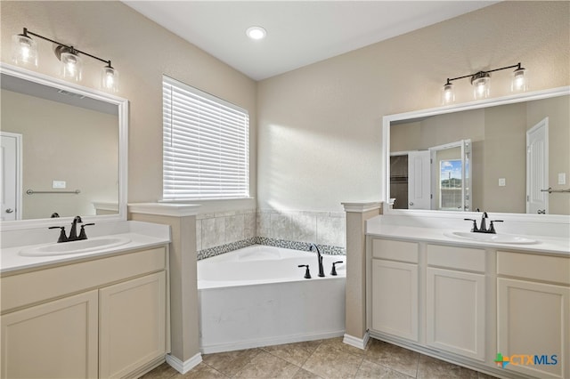 bathroom featuring tile patterned flooring, vanity, and a bath