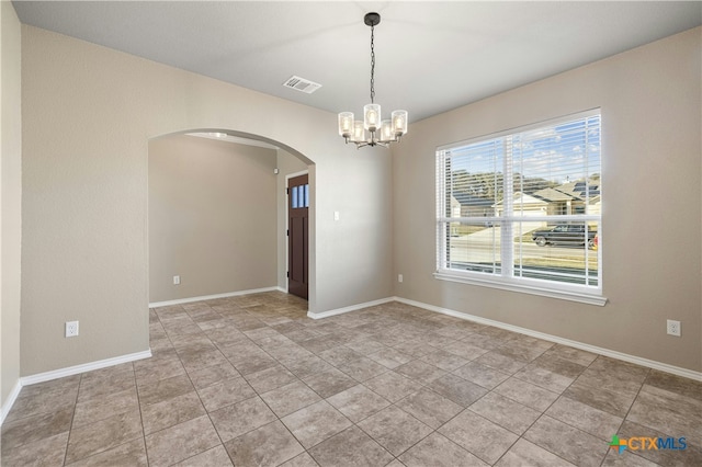 tiled empty room with a chandelier