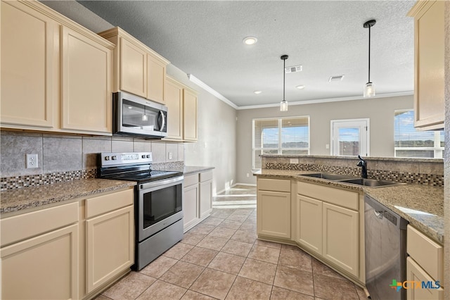 kitchen with appliances with stainless steel finishes, sink, light tile patterned floors, decorative light fixtures, and cream cabinetry