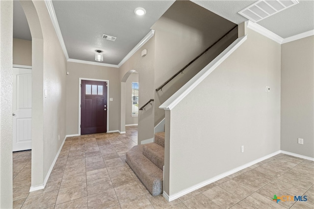 entryway featuring light tile patterned flooring and ornamental molding