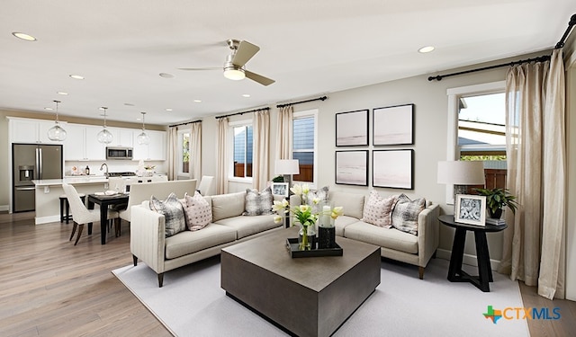 living room with ceiling fan and light hardwood / wood-style floors