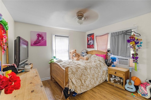 205 E Johnson St, Cuero, TX 77954 - bedroom with wood finished floors, cooling unit, and ceiling fan