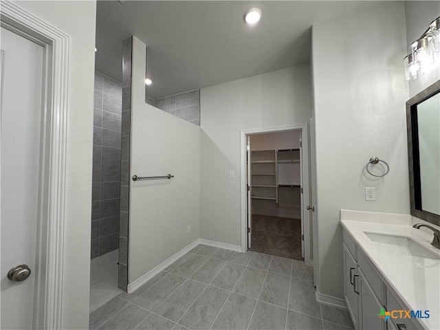 bathroom with vanity, tile patterned flooring, and tiled shower