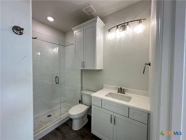 bathroom featuring toilet, an enclosed shower, and vanity