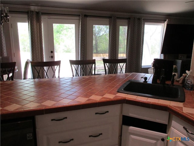 3512 Magnolia Blvd, Temple, TX 76502 - kitchen featuring tile counters, a sink, and white cabinetry