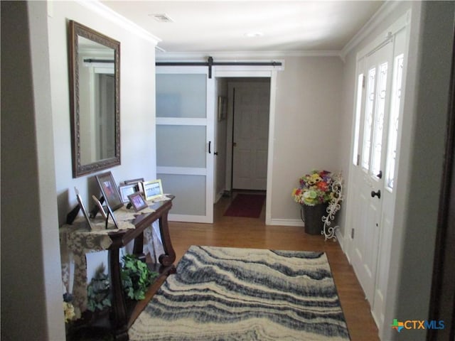3512 Magnolia Blvd, Temple, TX 76502 - hall featuring ornamental molding, a barn door, wood finished floors, and baseboards