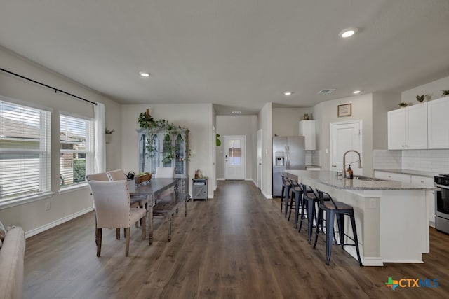 dining room featuring sink and dark wood-type flooring