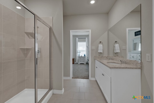 bathroom featuring vanity, tile patterned floors, and a shower with door